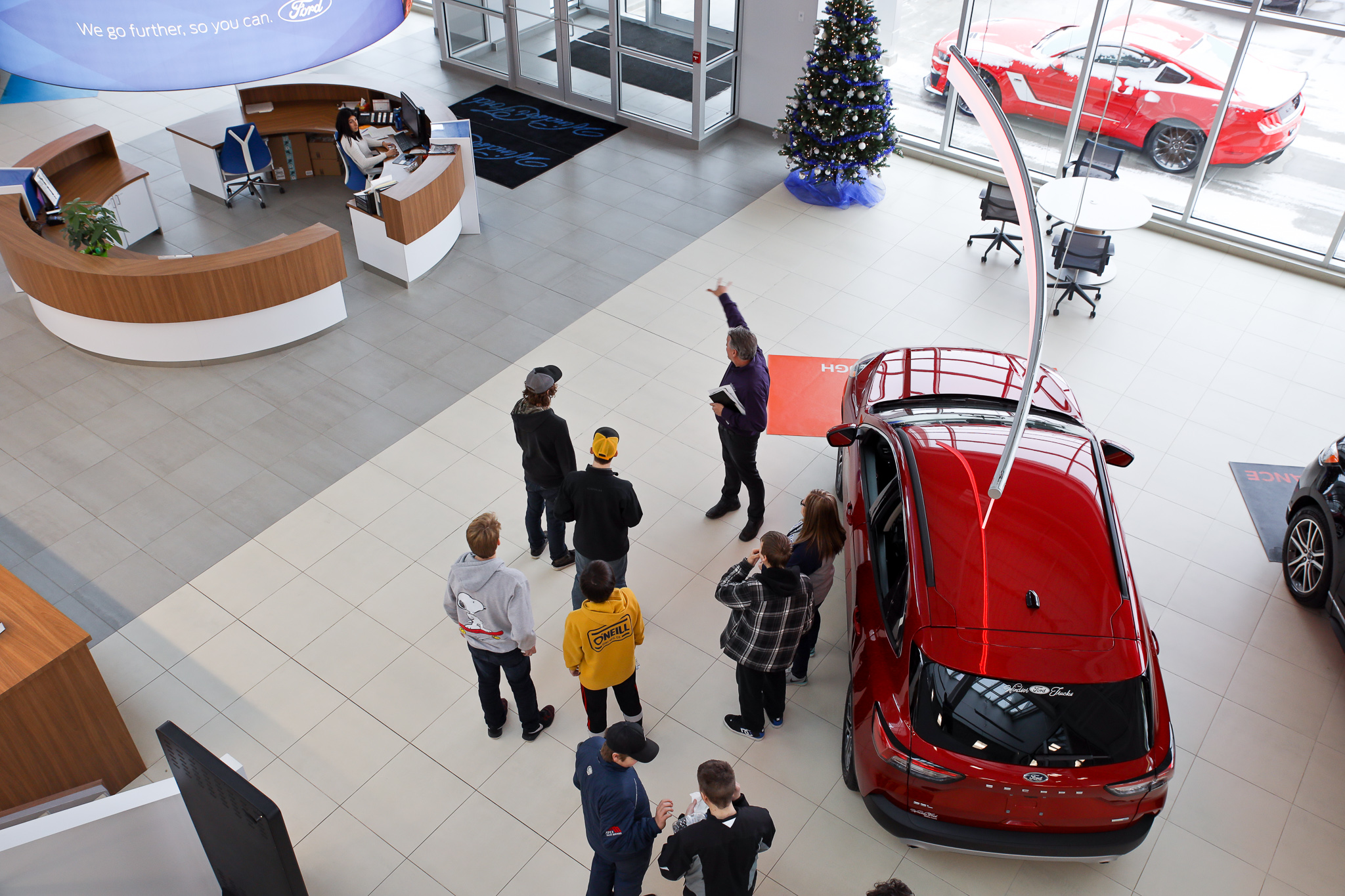 A Windsor Ford team member leading a group on a tour through the showroom