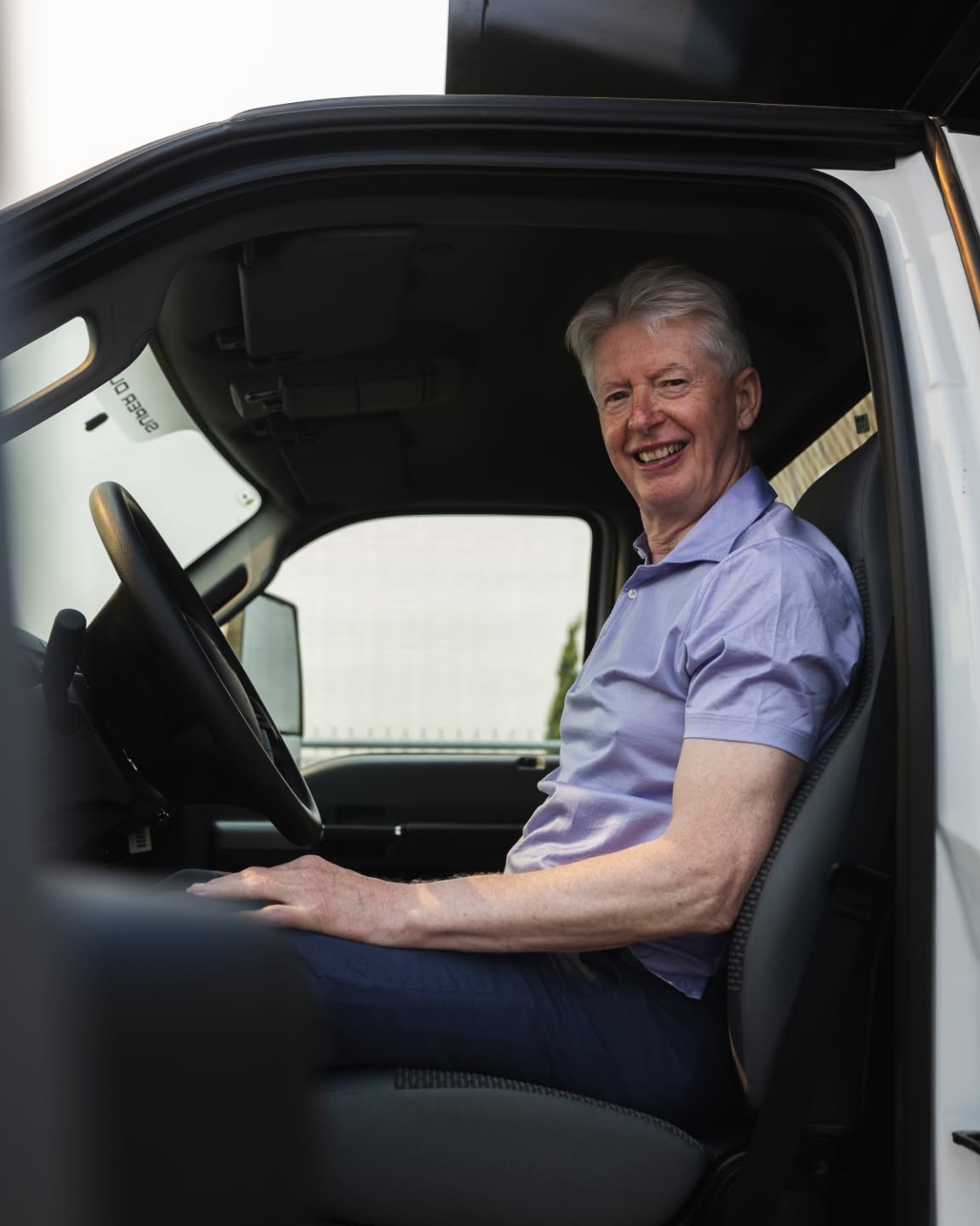 A longtime Windsor Ford team member smiling in the cab of a Ford Super Duty