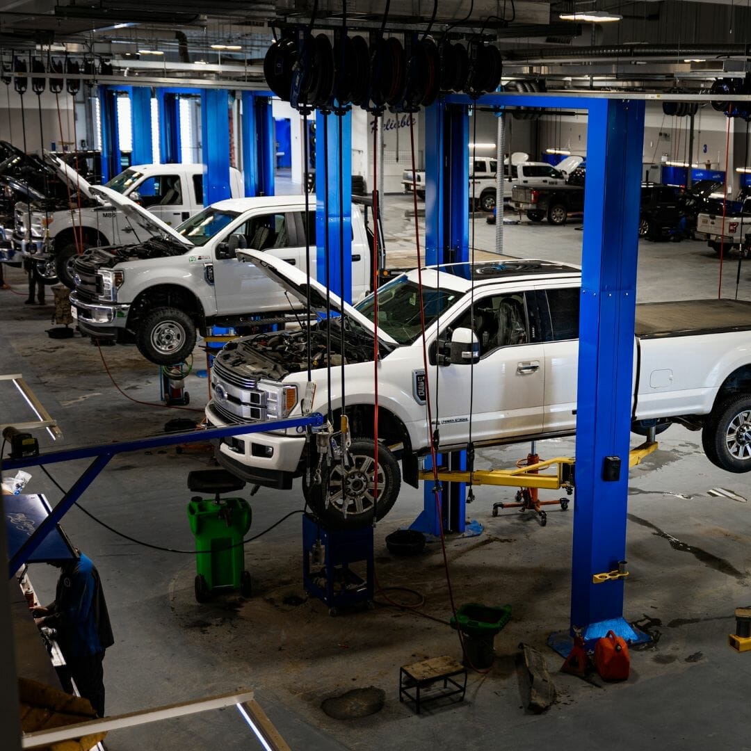 Ford Super Duty work trucks up on the hoists inside the Windsor Ford service shop