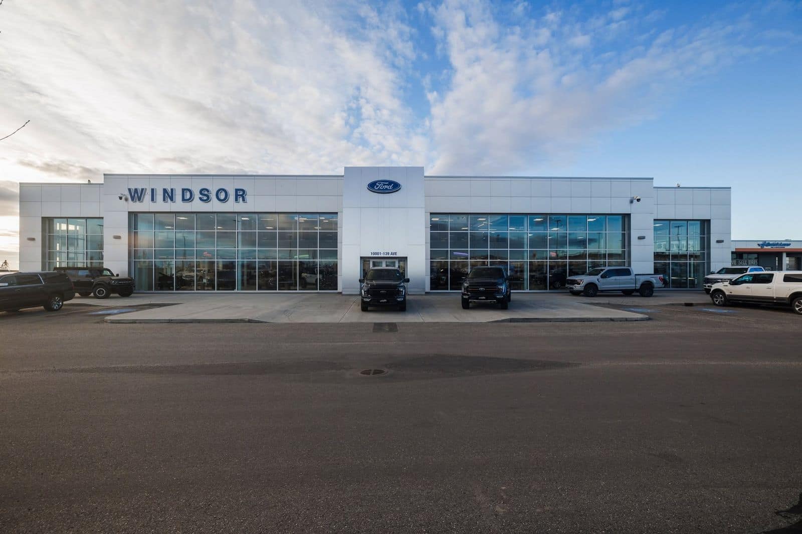 The Windsor Ford dealership in Grande Prairie today — the modern showroom building with F-150s and a Bronco out front